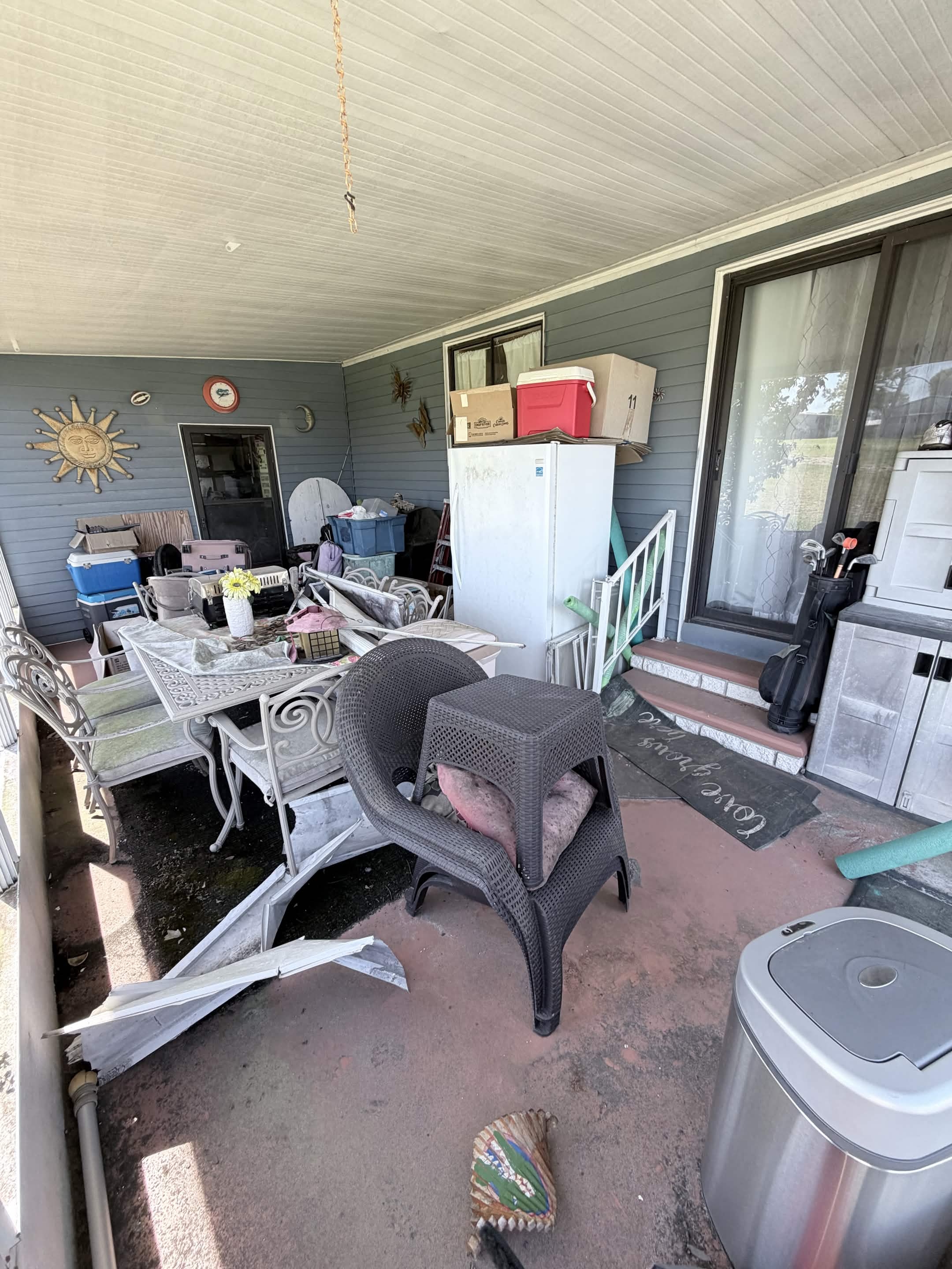 Cluttered patio with old furniture and appliances before Aventis Junk Removal cleanout in Kissimmee, FL